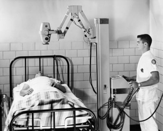 Poster print of a male radiologist taking an x-ray of a patient.