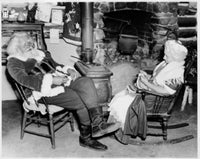 Santa Claus sitting with a senior woman by the fireplace poster print.