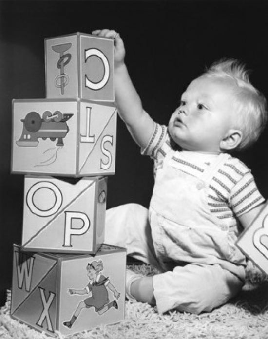Baby boy sitting next to a stack of colorful blocks poster print.