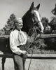 Young woman with horse on ranch poster print showcasing country life.