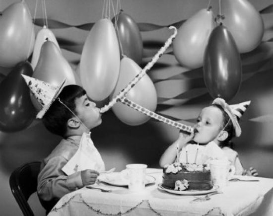 Two boys blowing noisemakers at a birthday party poster print