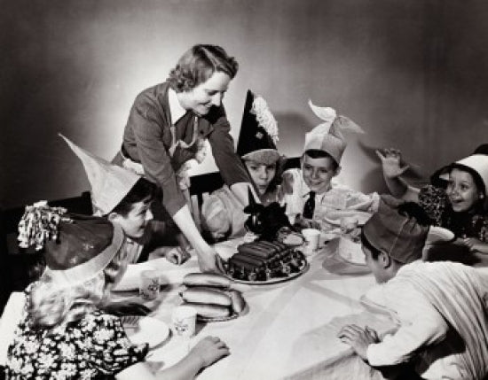 Young woman serving hot dogs to children at a party poster print
