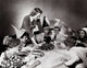 Young woman serving hot dogs to children at a party poster print