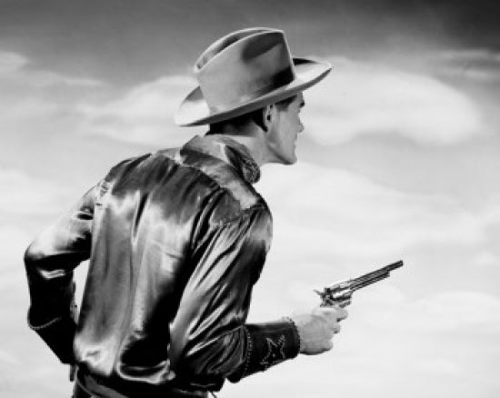 Rear view of a cowboy holding a pistol poster print.
