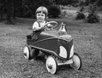 Portrait of a girl driving a toy car, vibrant colors and playful imagery.