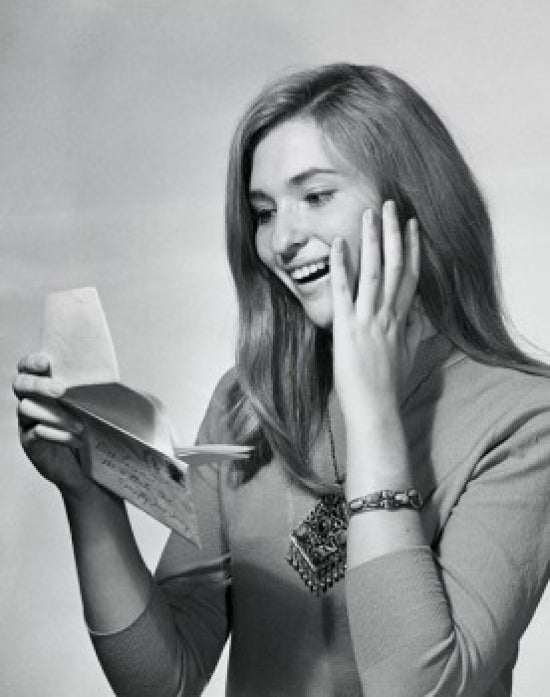 Close-up poster print of a teenage girl smiling while reading a letter.