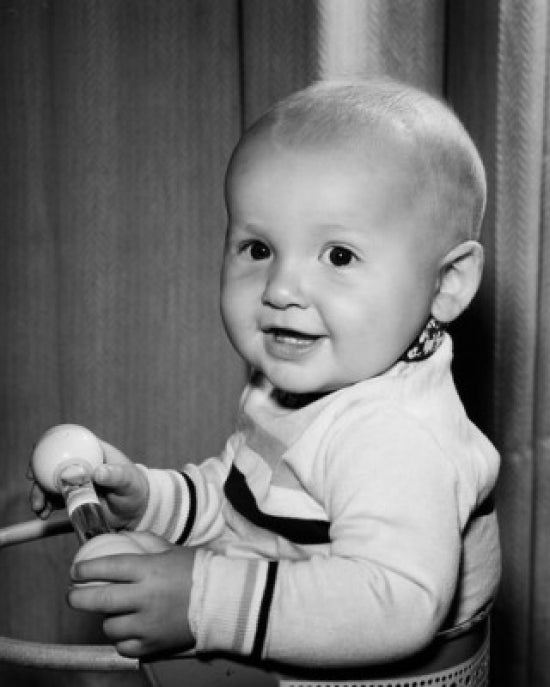 Portrait of a smiling baby holding a toy, cheerful and joyful.