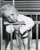 Close-up of a baby boy leaning over a crib poster print.