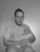 Portrait of a father holding his baby poster print