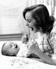 Young woman playing with baby on bed poster print