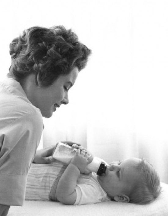 Mother feeding baby with bottle poster print in soft colors.