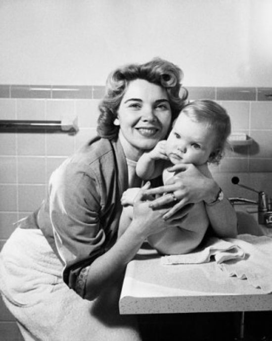 Young woman hugging her baby and smiling poster print