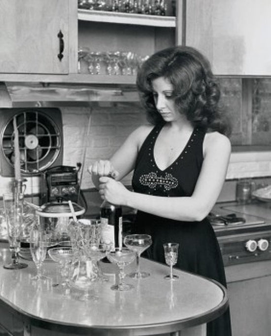 Young woman opening a wine bottle poster print, perfect for home decor.
