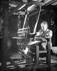 Senior woman working on a loom poster print showcasing traditional craftsmanship.