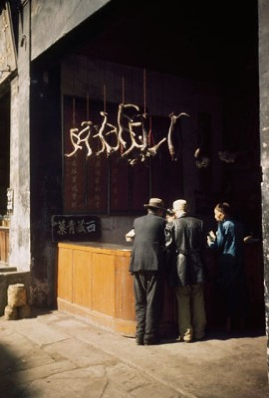 Poster print of a rear view of three people at a herbal medicine store in China.
