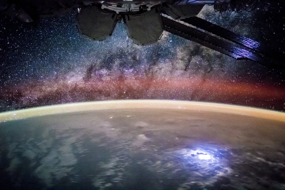 Lights Above and Below the ISS Poster Print showcasing Earth's glow from space.