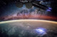 Lights Above and Below the ISS Poster Print showcasing Earth's glow from space.