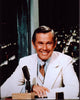 Johnny Carson sitting at desk in white suit photo print