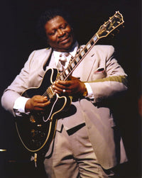 BB King performing on stage with black Les Paul guitar in grey suit photo print