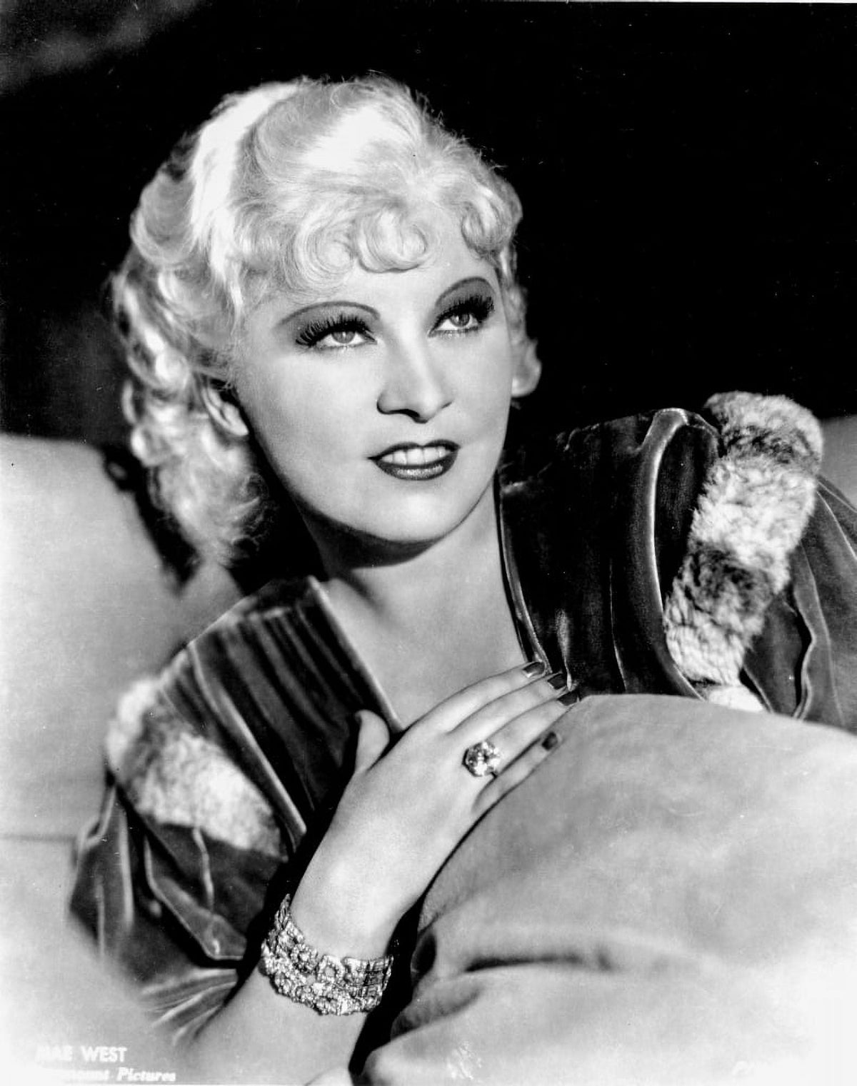 Mae West smiling in a classic black and white photo print.