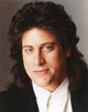 Richard Lewis posed in a black suit photography print.