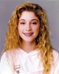 Staci Keanan smiling in a portrait wearing a white jumper photo print.