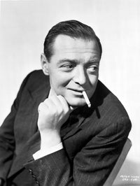 Black and white portrait of Peter Lorre in tuxedo, smoking cigarette.