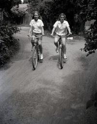 Two Teenage Girls Riding Bikes on Dirt Track Fine Art Print