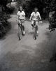 Two Teenage Girls Riding Bikes on Dirt Track Fine Art Print