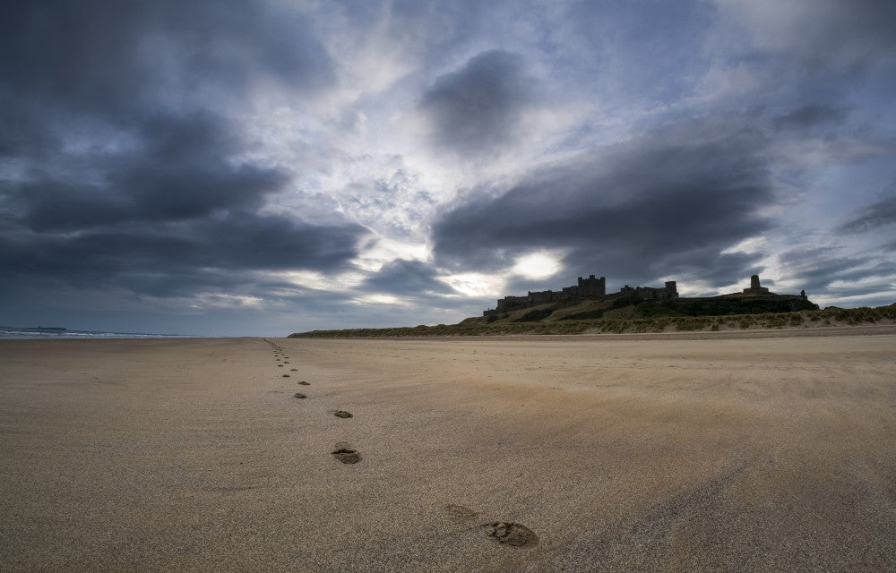 Footprints on the Beach with Bamburgh Castle Art Print by John Short