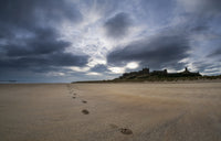 Footprints on the Beach with Bamburgh Castle Art Print by John Short