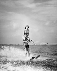 Young Man Waterskiing with Woman on Shoulders Fine Art Print