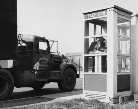 Mid Adult Man Talking on the Phone in a Telephone Booth Poster Print