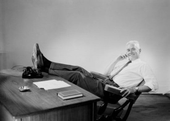 Senior Businessman Relaxing Behind Desk Fine Art Print
