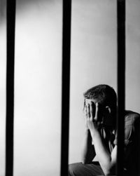 Male Prisoner Sitting in Prison Cell Fine Art Print
