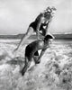 Young Couple Playing Leapfrog in Surf Fine Art Print