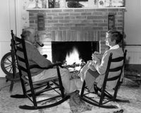 Senior Couple in Rocking Chairs by the Fireplace Fine Art Print