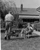 Man Mowing Lawn and Woman Reading Newspaper Fine Art Print
