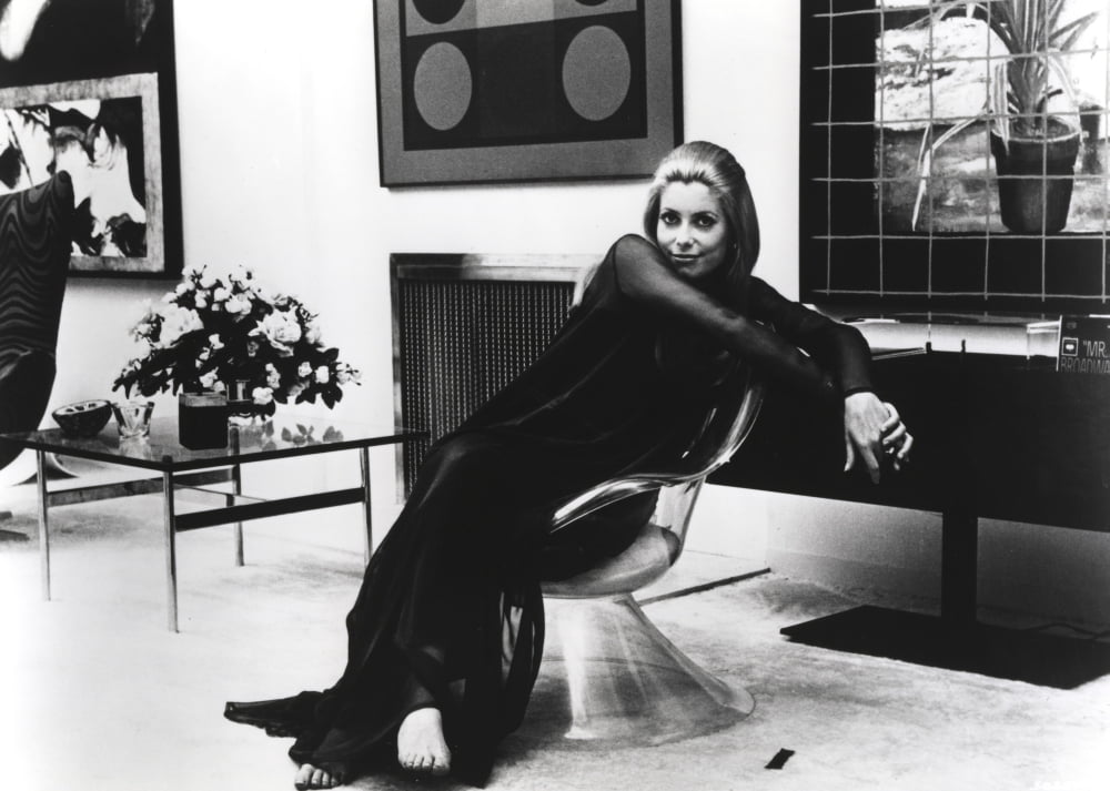 Classic photo print of Catherine Deneuve seated, showcasing her elegance.