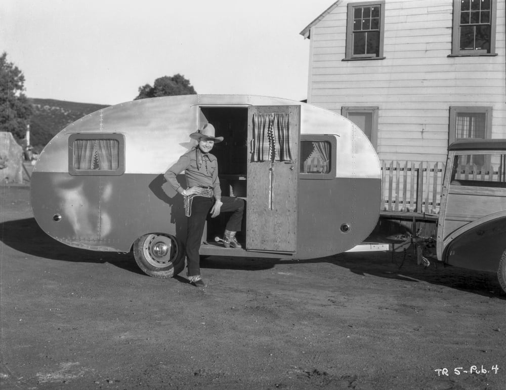 Tex Ritter photo print beside his trailer, capturing classic Americana.
