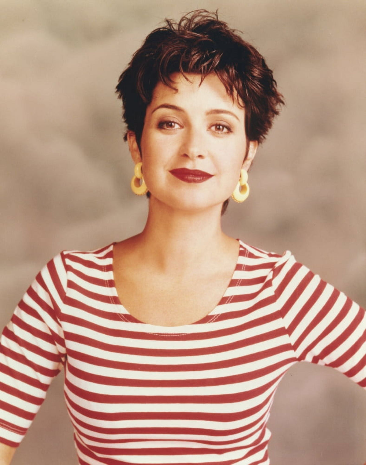 Annie Potts photo print in red and white striped top with yellow earrings.