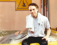 Jonathan Brandis posing with a dolphin photo print