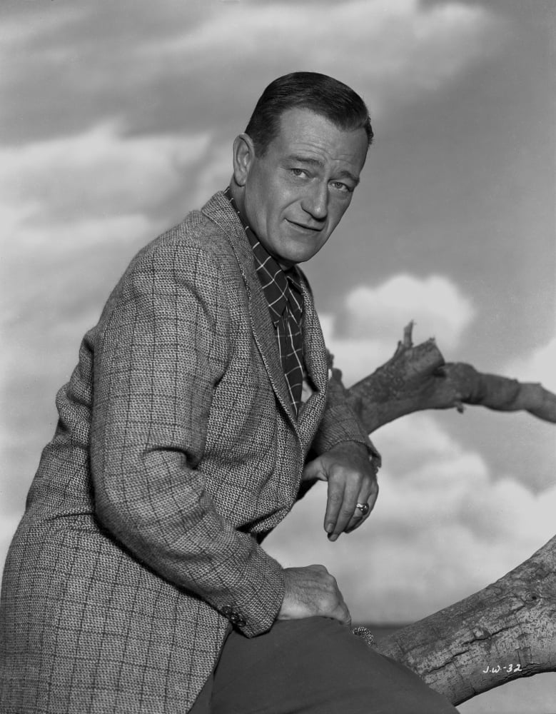 Black and white portrait of John Wayne in a suit coat
