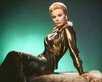 Elke Sommer photo print in a gold dress sitting on fur, showcasing elegance and glamour.