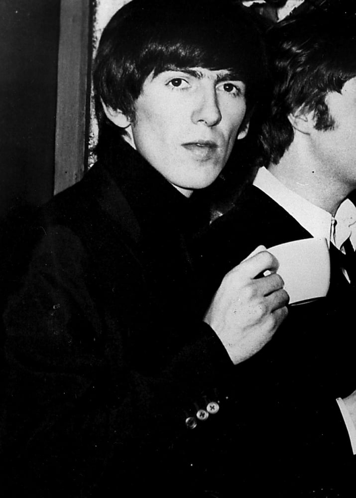 George Harrison holding a teacup photo print, capturing a moment of rock history.
