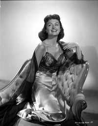 Donna Reed kneeling on a couch photo print.