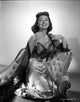 Donna Reed kneeling on a couch photo print.