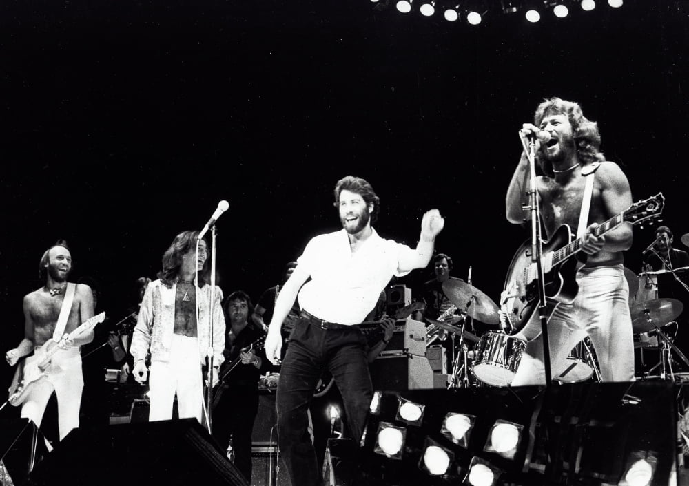 The Bee Gees performing live on stage with John Travolta photo print.