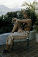 Claudia Cardinale seated on a metal chair photo print.