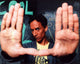 Danny Pudi Community photo print with hands up to camera.